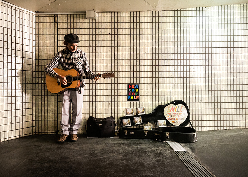 street grad photo of man playing guitar