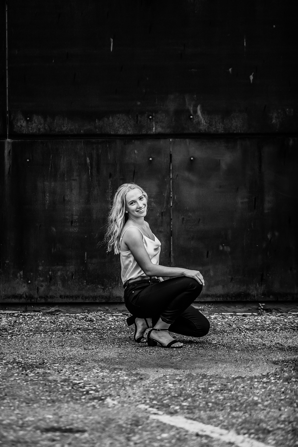 Grads photography image of a teenage girl with long blonde hair kneeling on the ground.