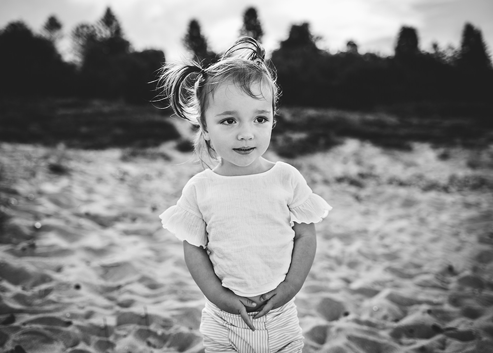 b&w photo portrait of toddler girl on a beach