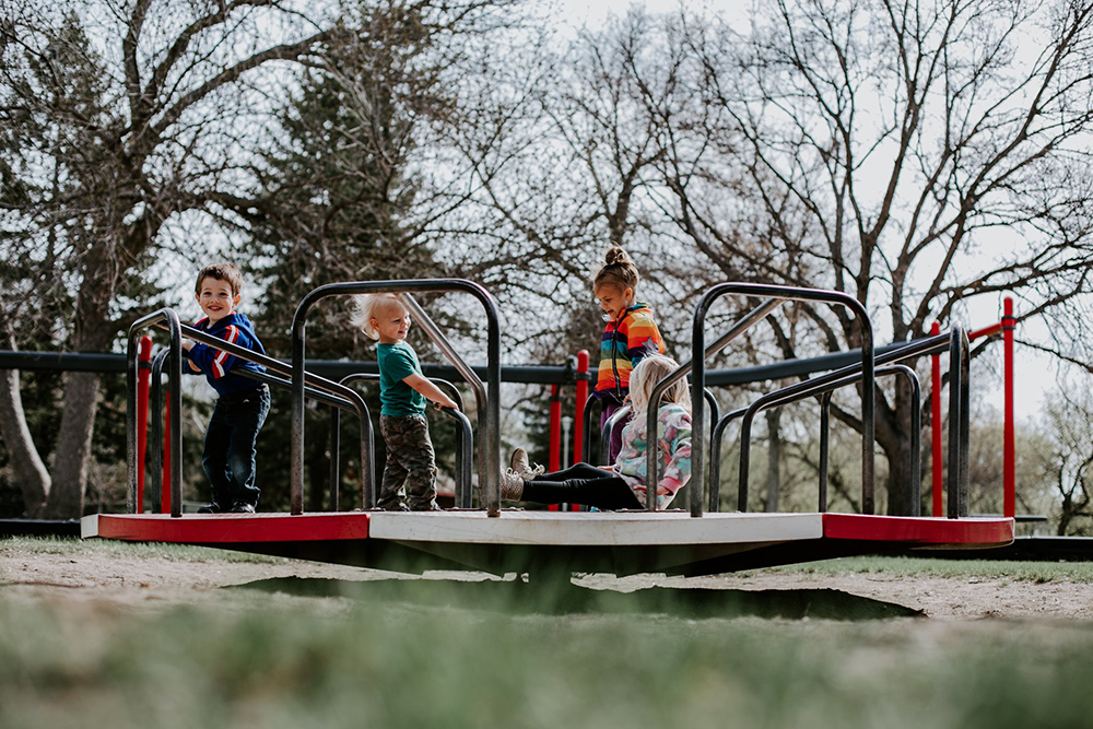 children on spinning equipment at a park