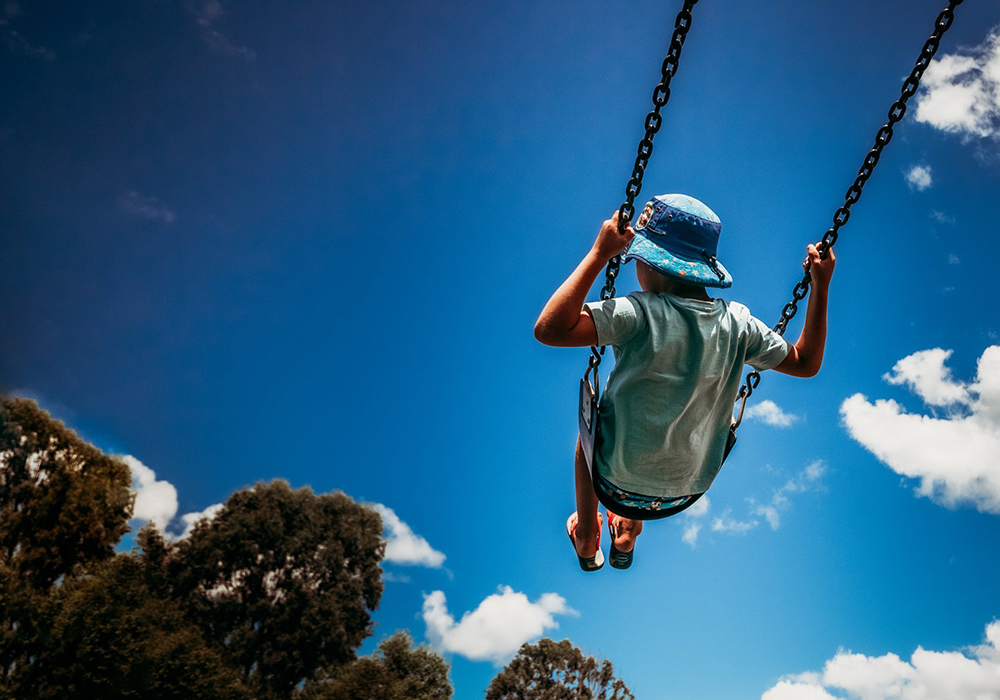 boy swinging high on park swing