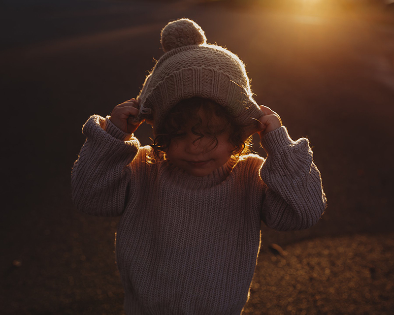 toddler boy wearing a beanie in late afternoon sunlight