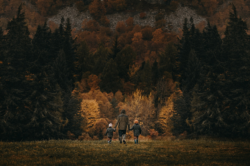 dad and two girls walking in a fall field