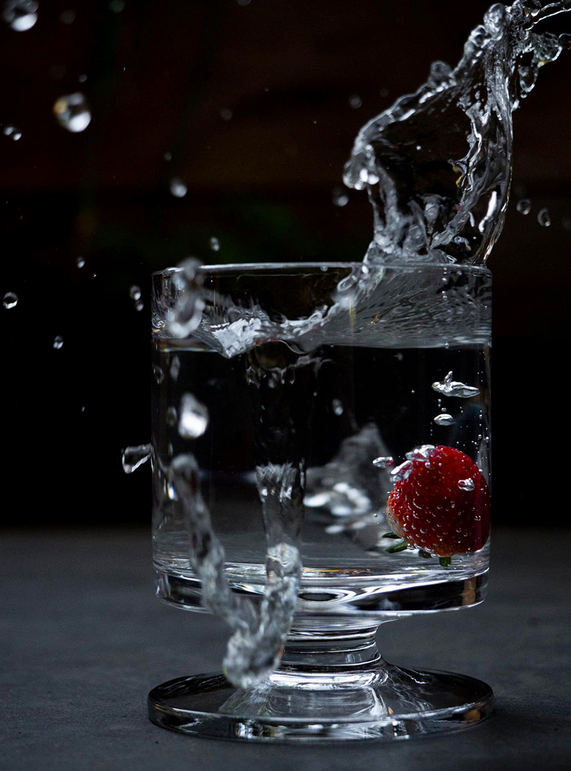 strawberry in a glass of water with a splash