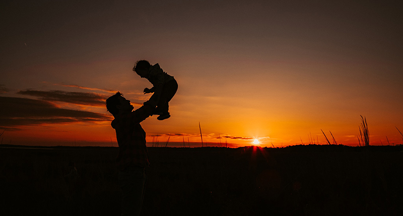 sunset silhouette photo of man with baby