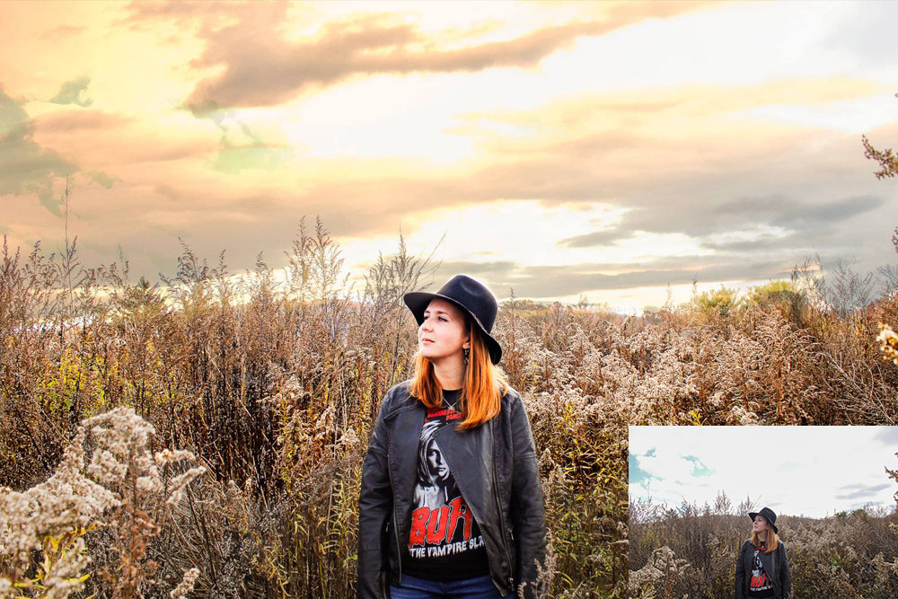 young woman with ginger hair and black hat at sunset
