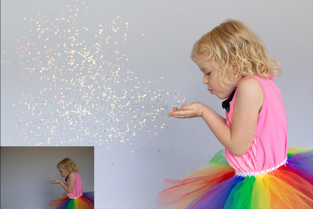 preschool girl wearing rainbow skirt blowing glitter