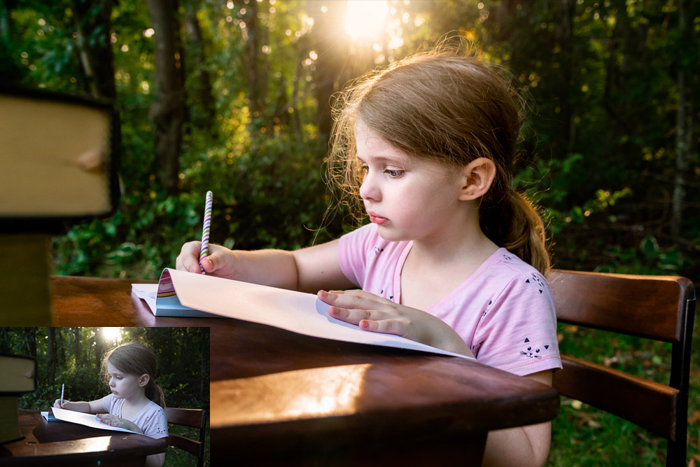 Young girl sitting at desk doing schoolwork outside