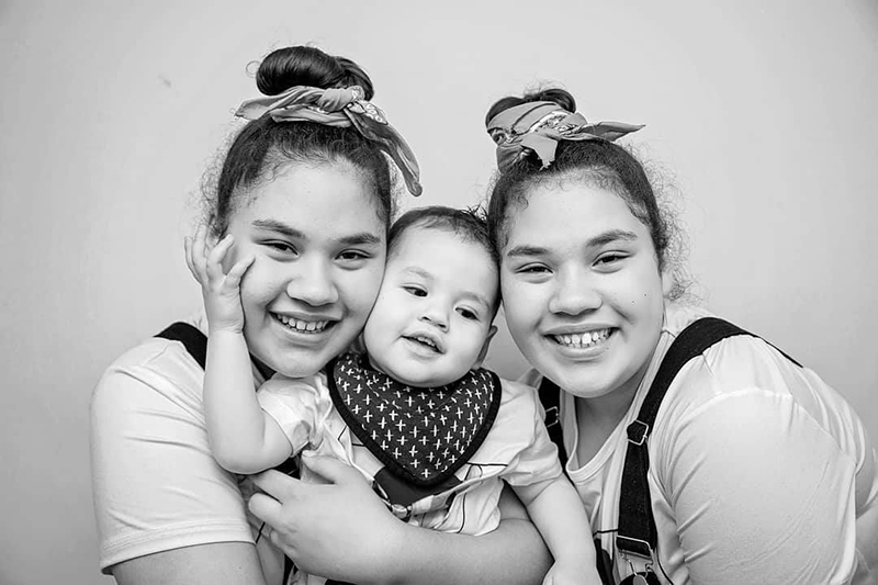monochrome picture of twin girls with baby boy