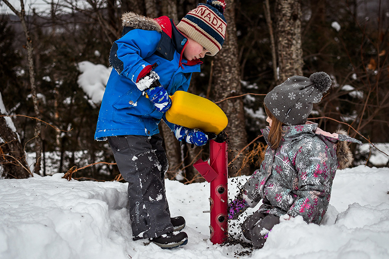 a boy and girl playing outside in winter