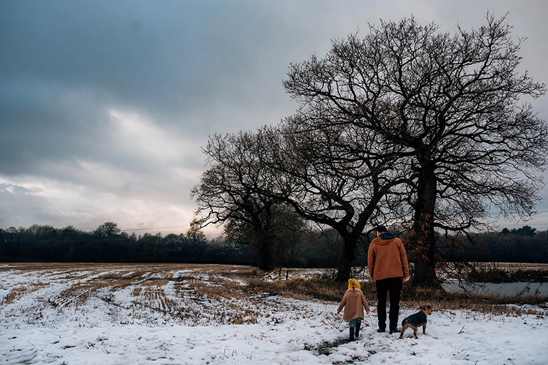 a dad, his small daughter and a dog in the snow