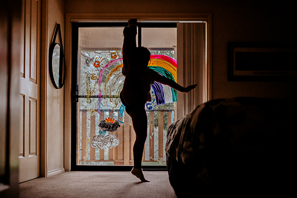 Silhouette of young girl dancing indoors