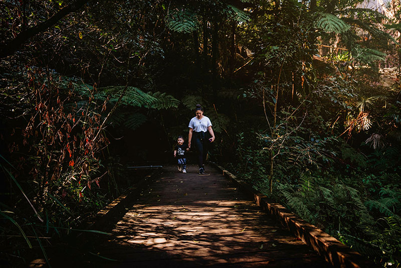 teenage girl and toddler boy on boardwalk in the bush