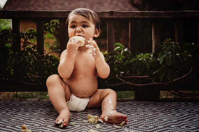 baby eating cake outdoors