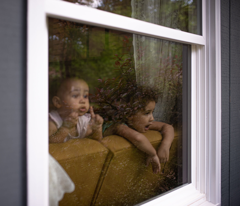 2 children looking out a window