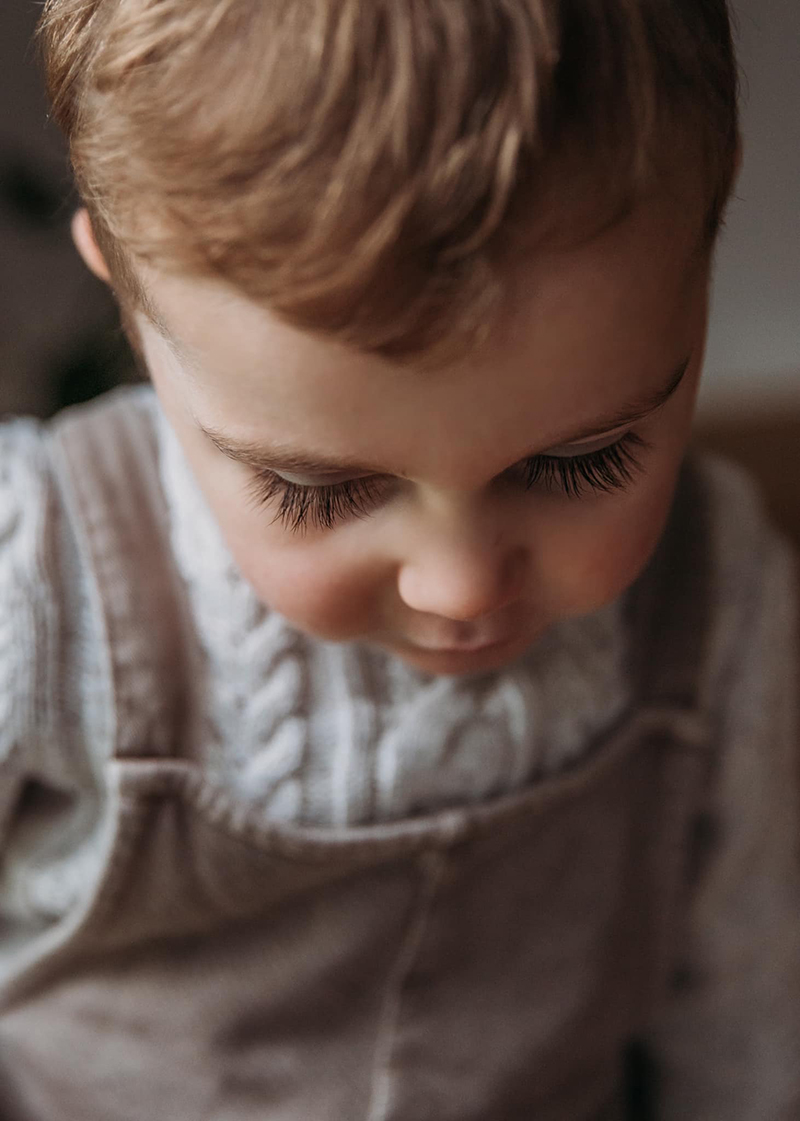 toddler portrait of boy's eyelashes wearing white sweater