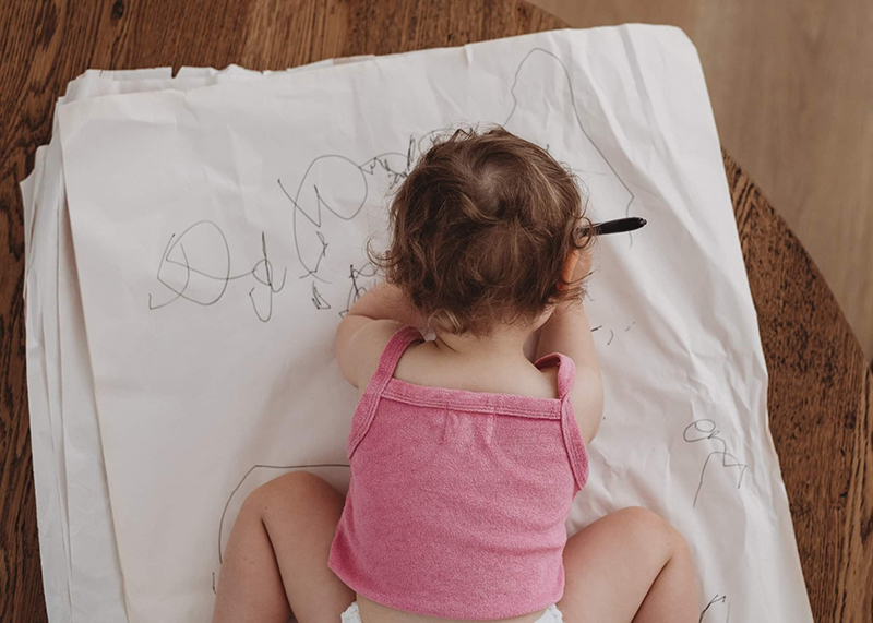 girl toddler photo wearing pink top drawing on paper