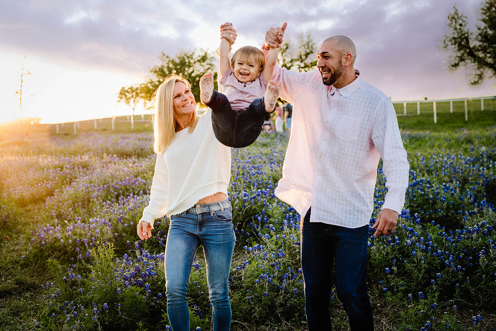 portrait of mum and dad with toddler at golden hour outdoors