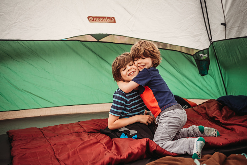 young brothers embracing in tent