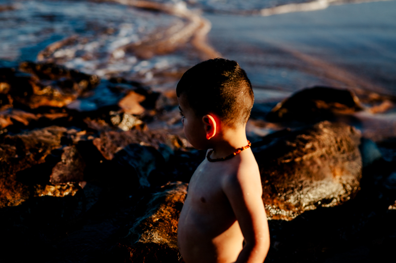 toddler boy on beach with face partially in shadow