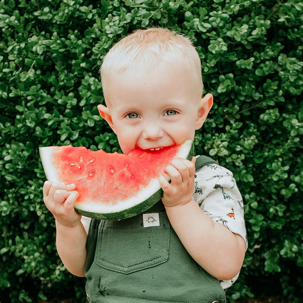 young blonde boy eating watermelon