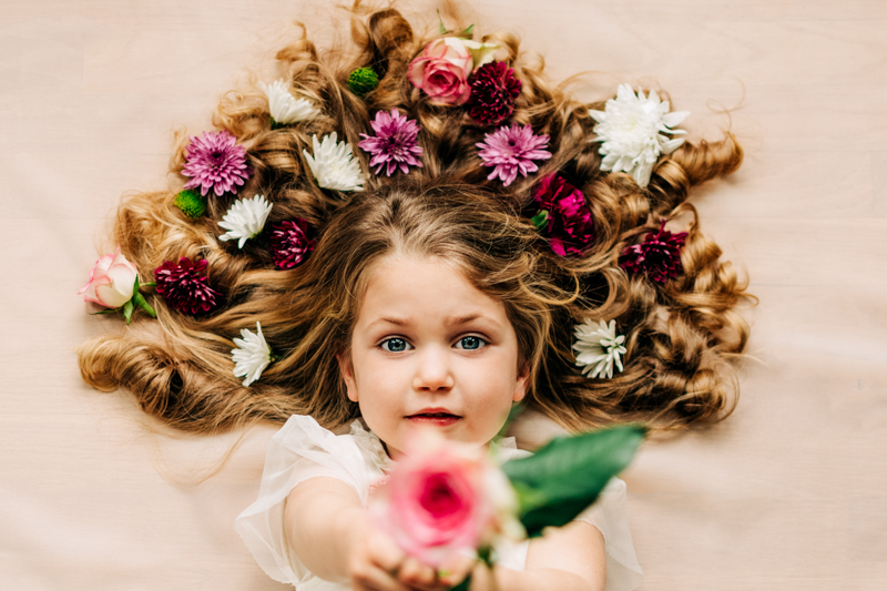 beauty portrait of girl holding a flower from top-down angle