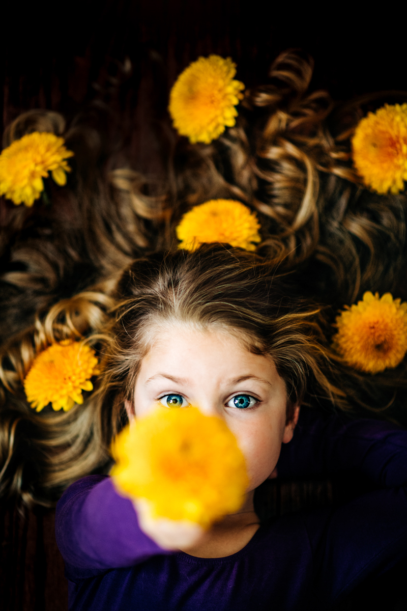 young girl photography portrait holding flower with face in focus