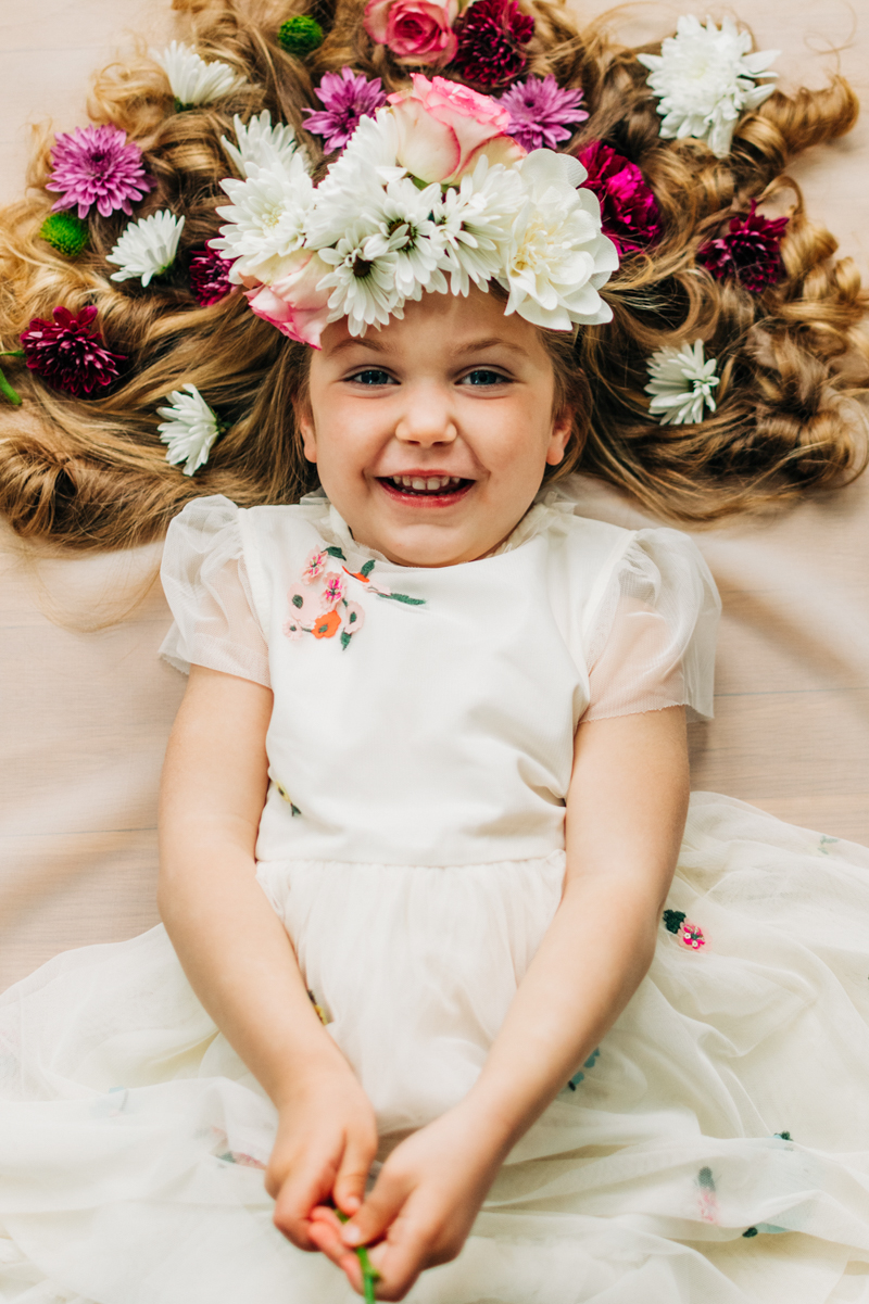 portrait of young girl lying down wearing a flower crown
