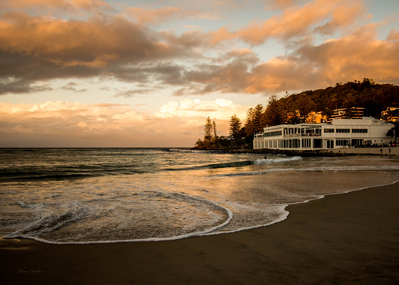 golden hour landscape photo of beach with building and trees