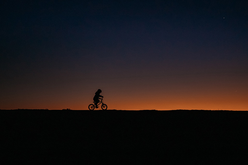 golden hour sunset silhouette photo of two boys in the desert