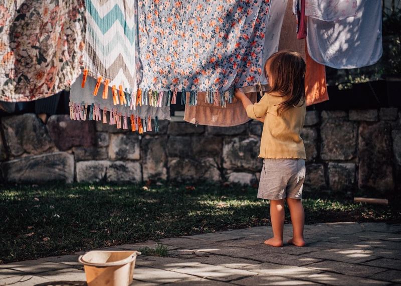 young girl hanging out washing