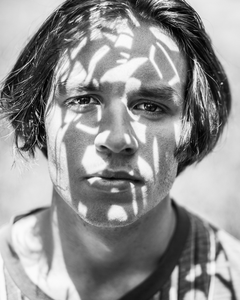 portrait of senior boy with shadow patterns on his face