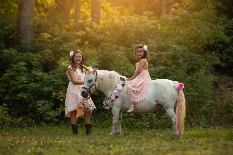 two young girls with white horse at golden hour