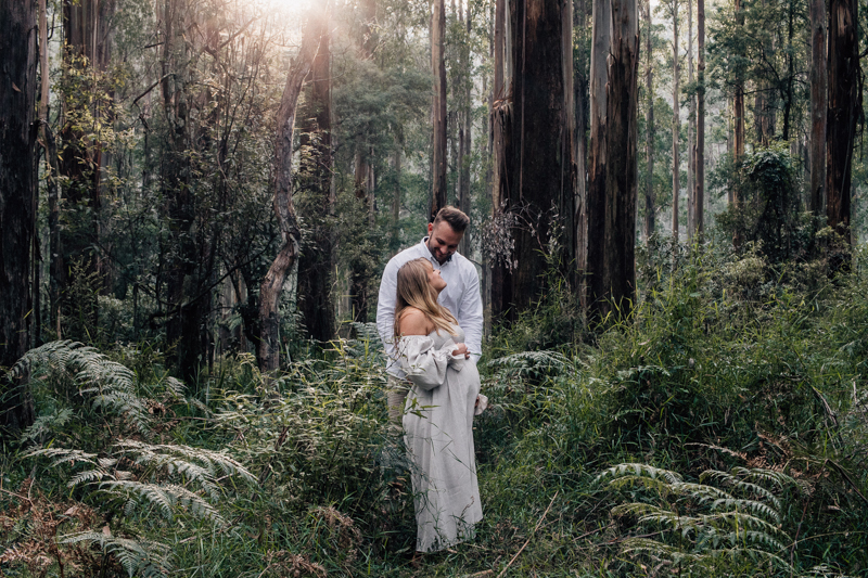 couple standing in the forest 