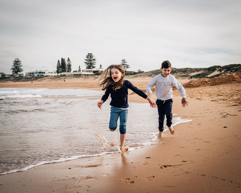 two children running on beach