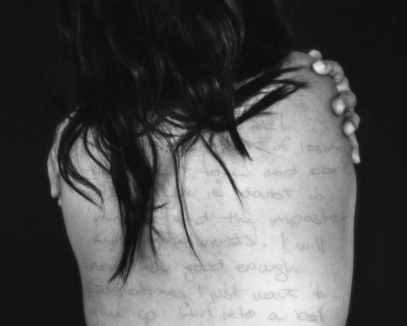 self portrait of woman's back with writing on it