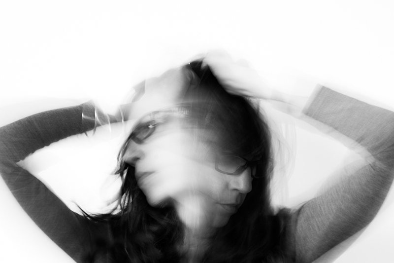 slow shutter speed self portrait of woman with arms on her head