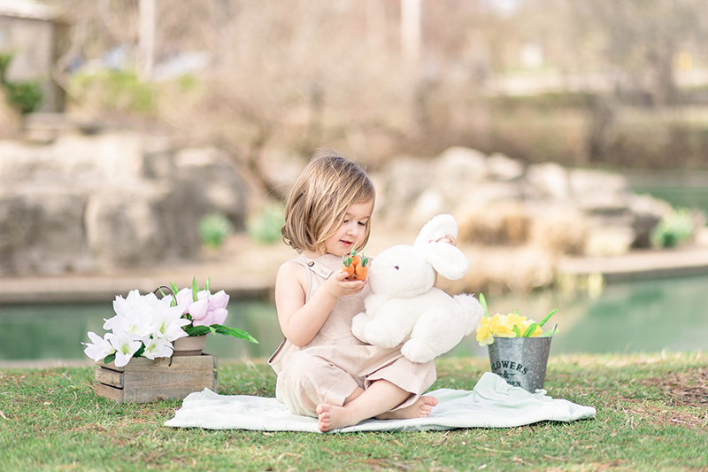 girl sitting on a rug with an easter bunny softie