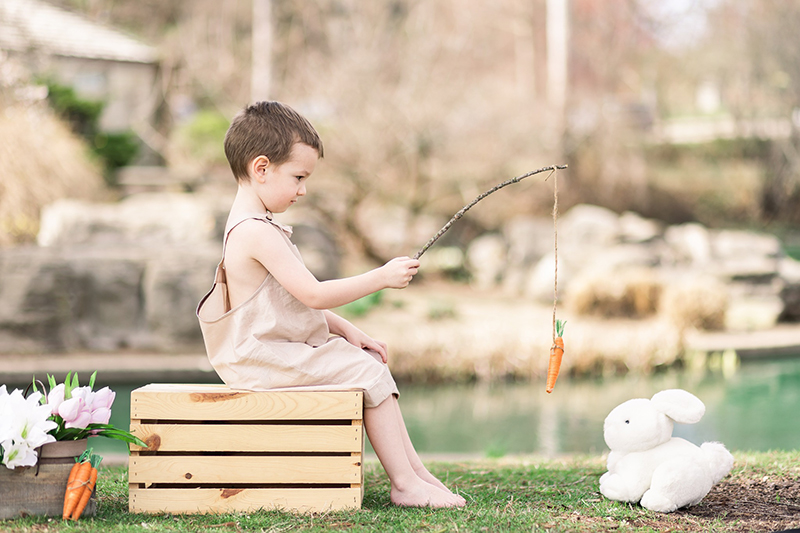 boy with a fishing rod sitting on a box