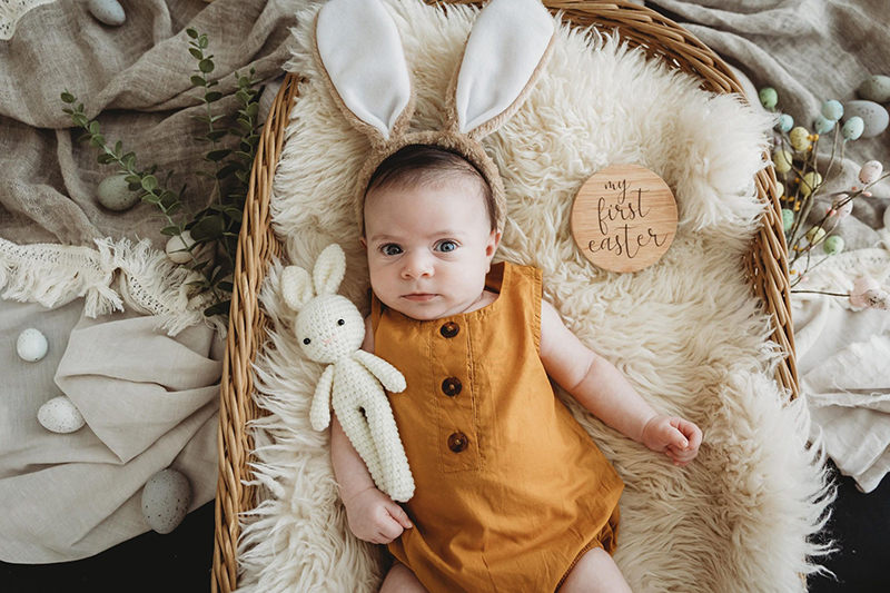 baby in mustard romper with bunny