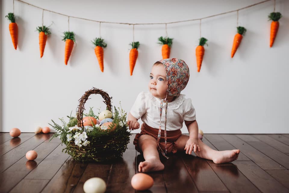 Easter portrait of baby girl with carrot garland and basket