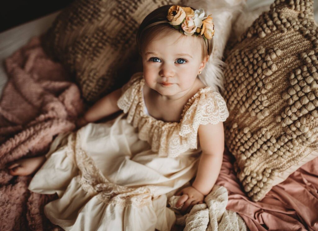 photo of baby girl in a cream dress
