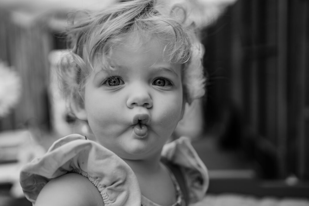 toddler pulling cute funny face for camera in black and white