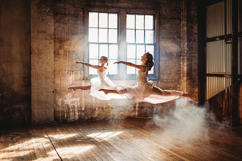 dancers jumping, backlight, warehouse