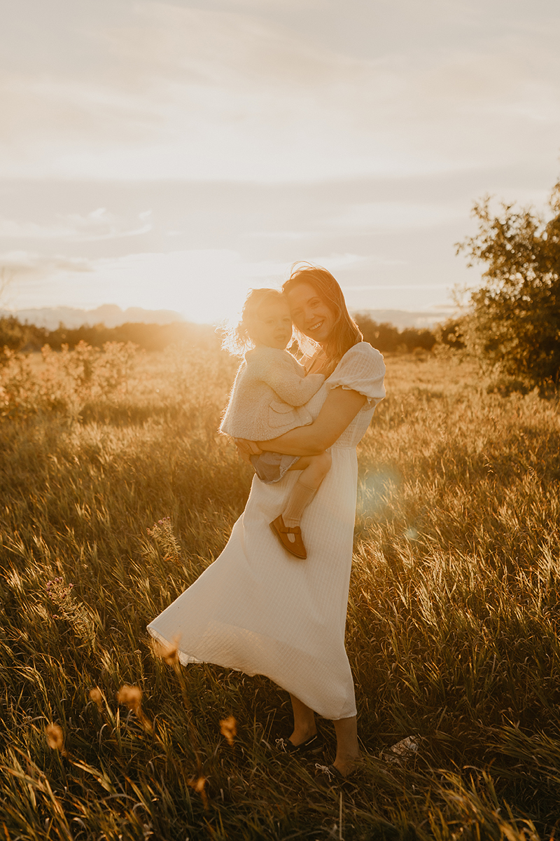 Portrait of mother and toddler in a field during golden hour photo session